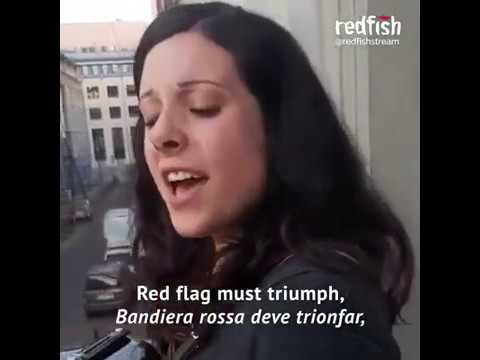 Woman on accordion sings Bandiera Rossa on balcony