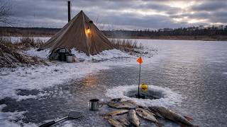 Winter ice fishing for pike - camp on the ice, hot tent and blizzard