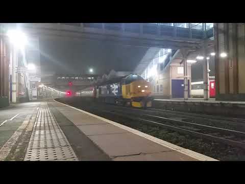 Large Logo 37402 with load 9 passes through a murky Ipswich Station
