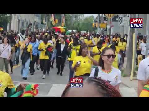 Ghanaians in Toronto march excitedly to the stadium ahead of the game.