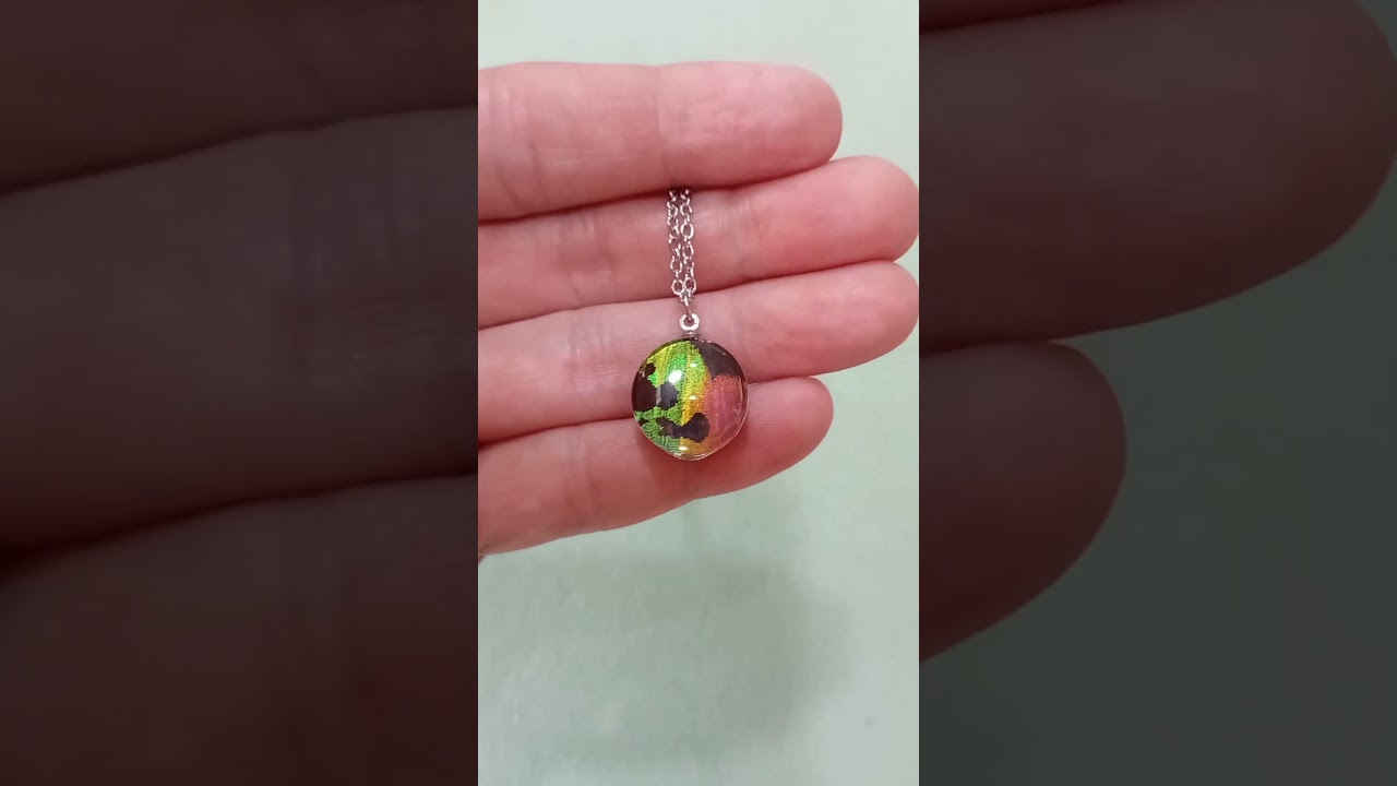 Collana artigianale da 16mm con vera ala di falena Urania ripheus sotto lente in vetro con elegante brillantezza metallica arcobaleno