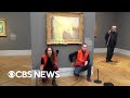 Climate activists throw mashed potatoes on a Monet painting to protest fossil fuel extraction