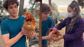 Joshua Bassett & Sofia Wylie holding a chicken on the set of hsmtmts