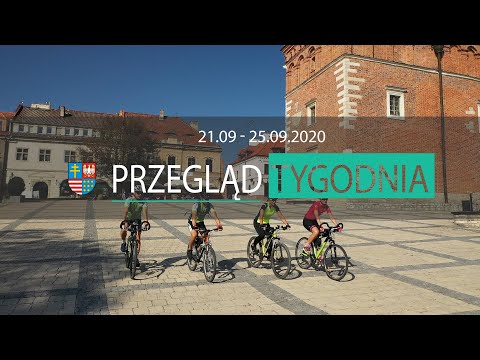 Rowerzyści na sandomierskim rynku. Plansza z napisem Przegląd tygodnia 21.09 - 25.09.2020