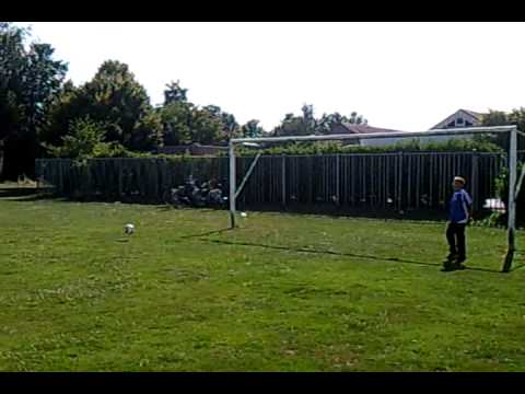 Een schot via de grond tegen de lat.