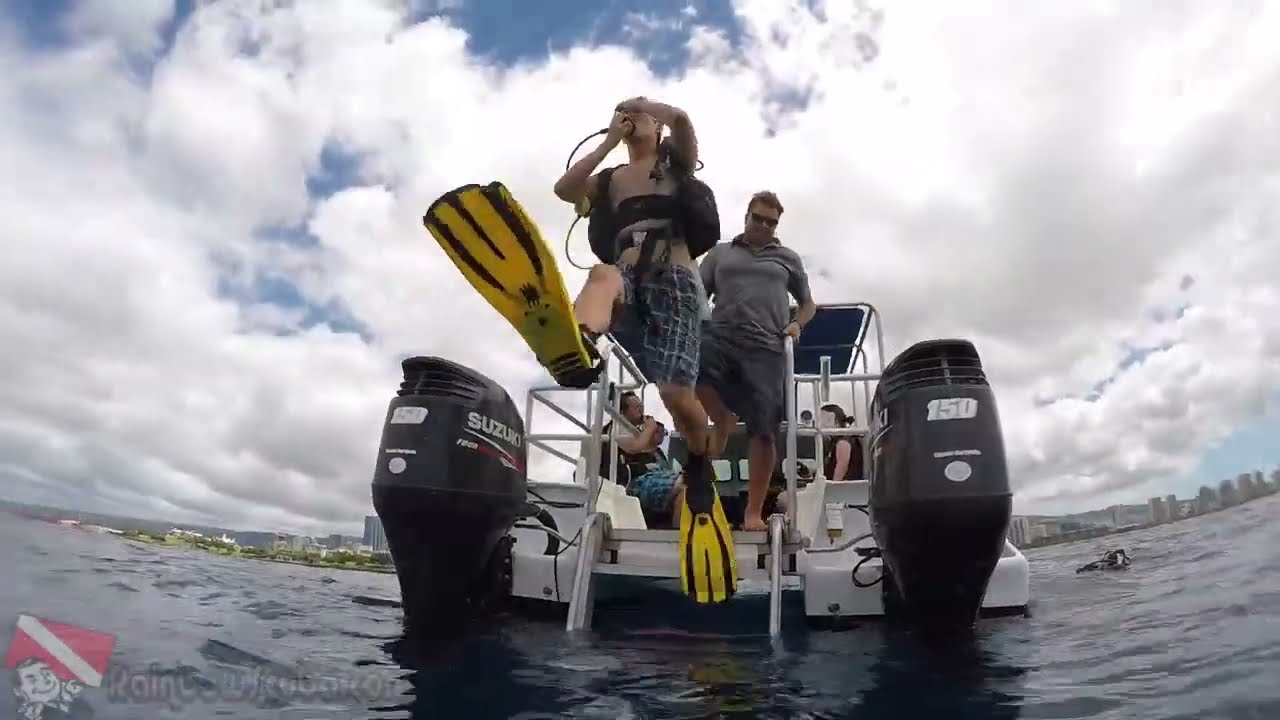 Two first-time divers make a giant stride entry into the Pacific Ocean in Honolulu.