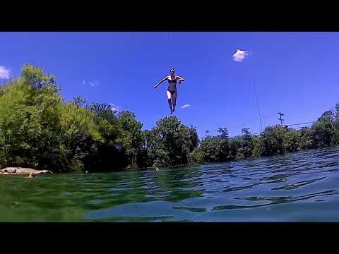 Girl rope swing into lake in slow motion