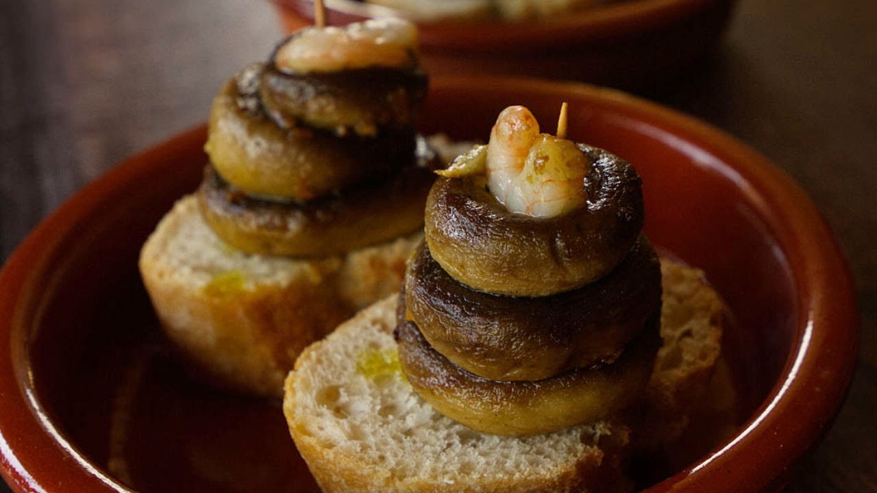 two tapas servings of bread with mushrooms stacked on top