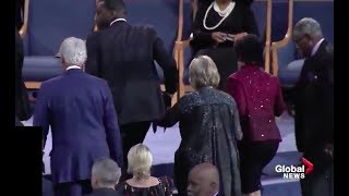 Two people help Hillary Clinton up stairs at Aretha Franklin funeral