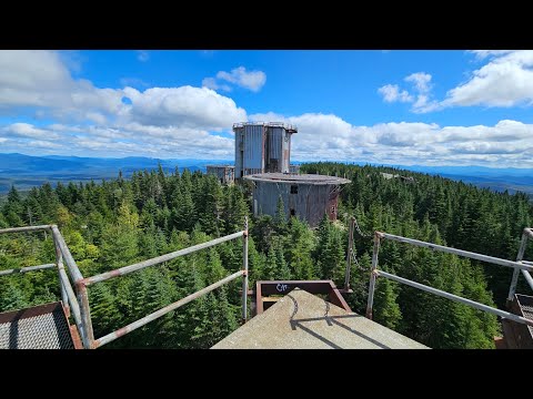 Abandoned Mountain Top Military Base Crumbling Rusting. Big Tanks And Flooded Road