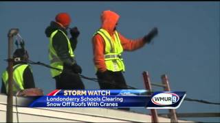 Cranes used to clear snow from school roofs