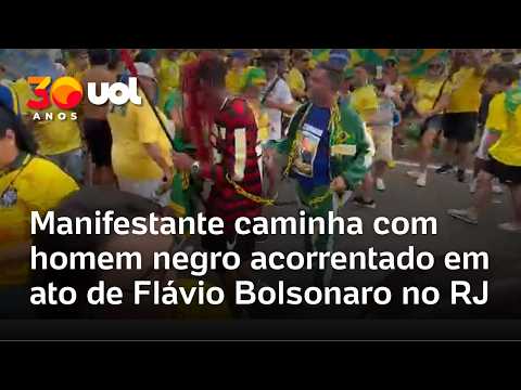 Manifestante bolsonarista caminha com homem negro acorrentado e vestido de petista em ato de Flávio