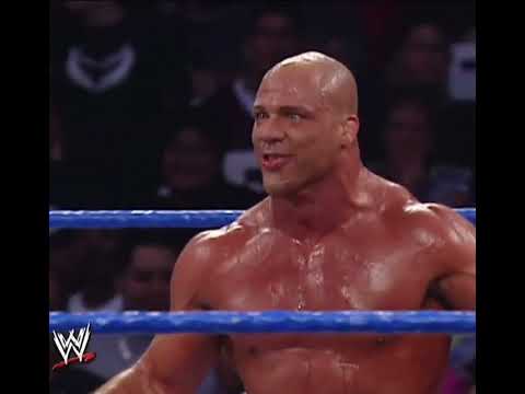 Kurt Angle shoots a tranquilizer dart at The Big Show.