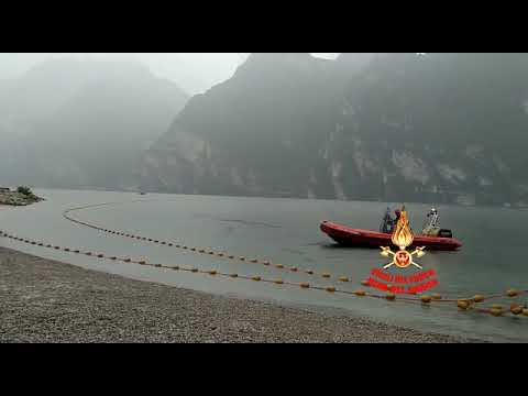 I vigili del fuoco di Riva del Garda posizionano le reti alla foce del Sarca