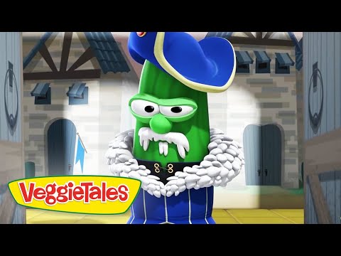 Green cucumber character wearing a blue royal coat with a white fur collar and hat, standing in a castle setting; VeggieTales logo visible on screen edge.