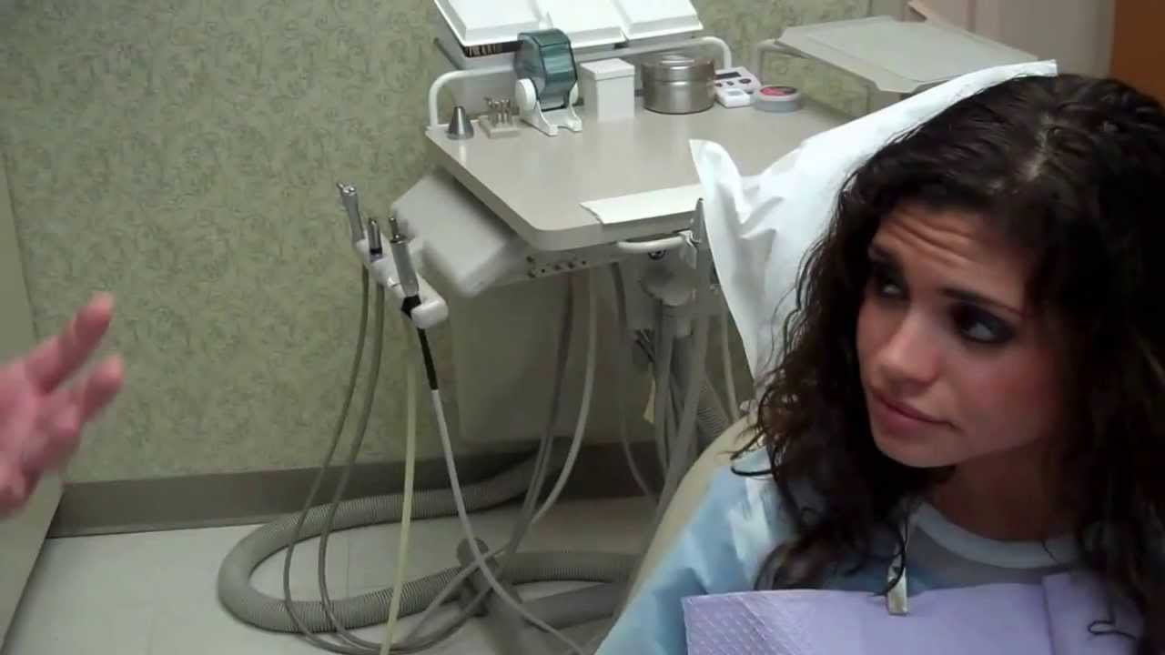 Woman in dental chair listening to her dentist talk