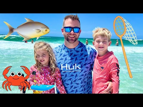 Family at the beach: father with two kids posing in the surf with cartoon sea creatures and a fishing net overlay nearby. coast and turquoise water in the background.