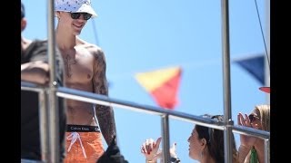 Shirtless Justin Bieber sips beer while lounging on a yacht surrounded by women...