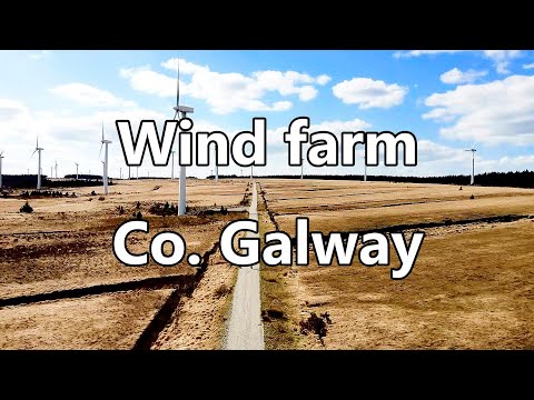 Over Barna beach and a wind farm in County Galway, IRELAND 4K