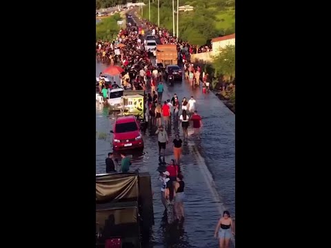 Moradores festejam em passagem molhada após barragem transbordar no Piauí