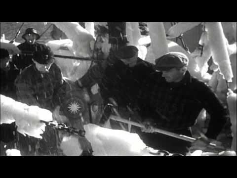 Men chop off ice from deck and rigging of frozen sailboats in Boston, Massachuset...HD Stock Footage