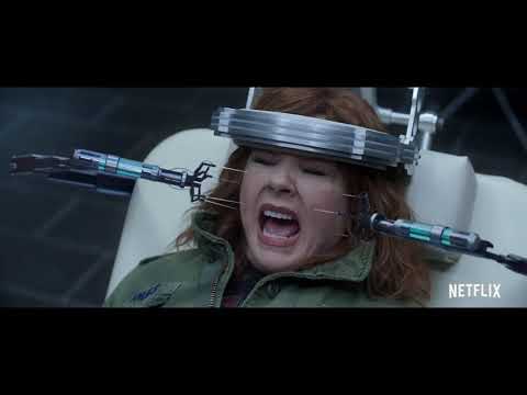Trailer frame: Emily and Lydia in armored suits while the score’s march hits