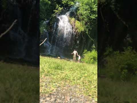 Walking into the waterfall at the campsite