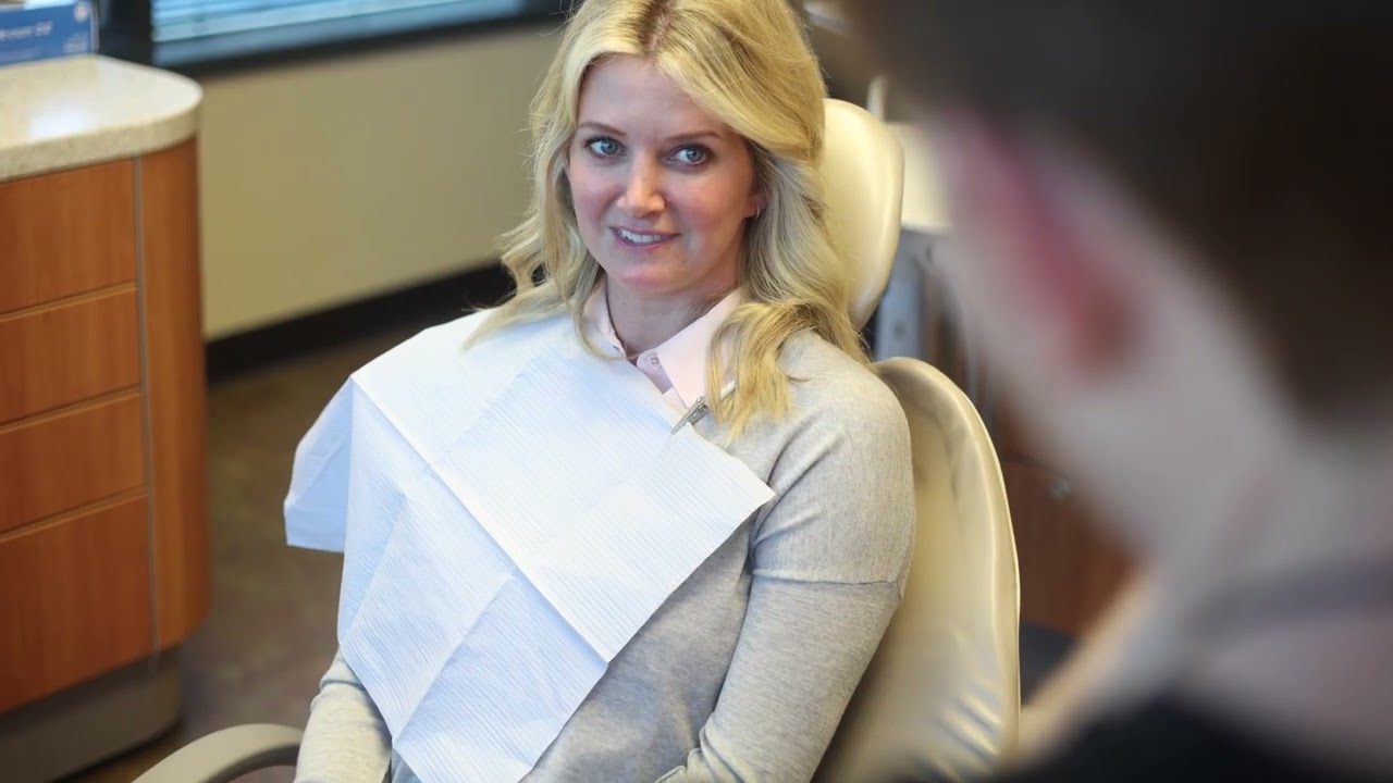 Woman in white blouse sitting in dental chair