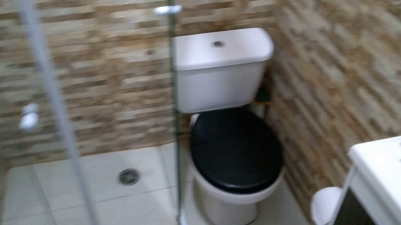 Banheiro pequeno com box de canto.