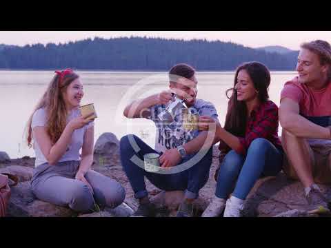 Group Of Happy Friends Sitting In Nature On Lake Beach Smiling And Pouring Coffee Friendship And