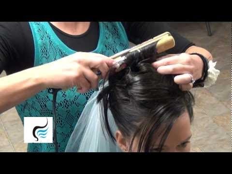 Hair stylist creating a soft bridal updo with braid detail, featuring a veil, suitable for wedding hairstyles tutorials.