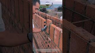 Brick wall construction technique: Traditional mason line leveling for perfect reinforced brickwork