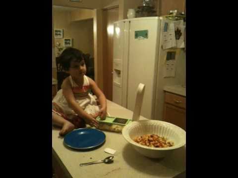 A 3 years old toddler making fruit salad