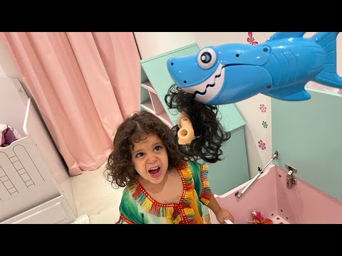 Amira joue avec un jouer requin￼