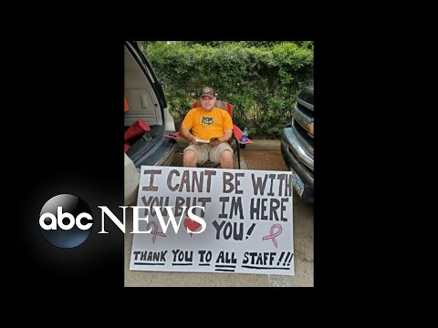 妻が化学療法を受ける際に病院の外でサインをする男性がいる｜WNT (Man holds sign outside hospital as wife receives chemotherapy | WNT)