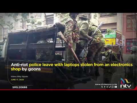 Anti-riot police leave with laptops stolen from an electronics shop by goons