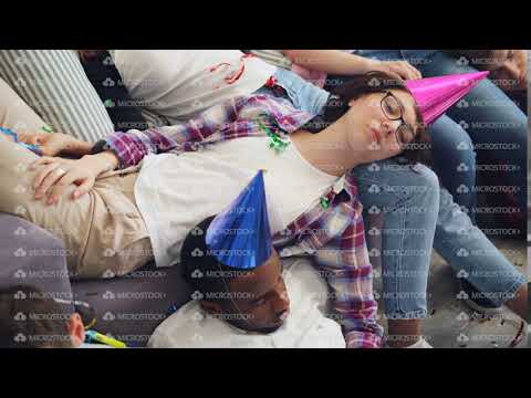 Men and women in party hat sleeping on couch and floor after celebration at home
