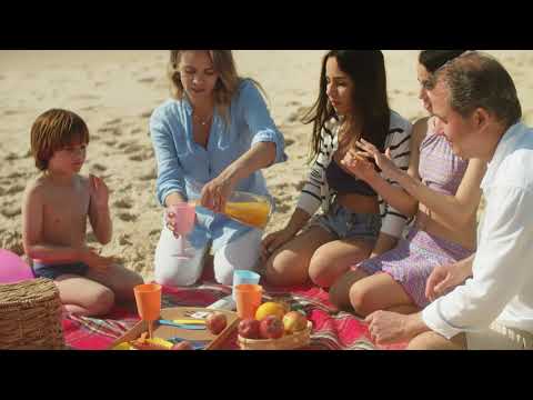 Family picnic on the beach eating snacks