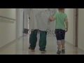 Child And Doctor Walking In Hospital Hallway