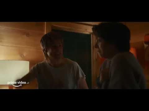 Trailer frame showing Abby and Gretchen in the haunted shack with flashlight beams cutting through darkness