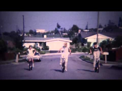 1972: 3 caucasian kids riding bikes uphill on residential suburban street. LOMITA, CALIFORNIA