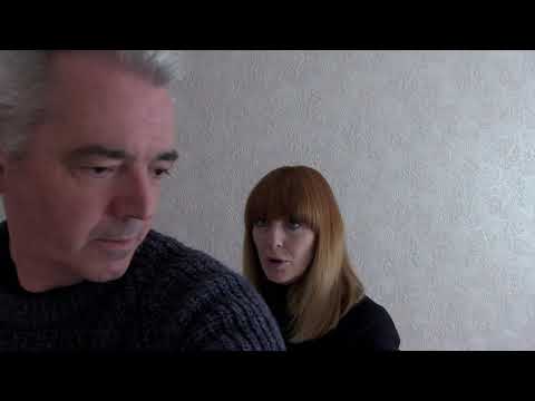 Static camera on the stairwell—percussive ostinato implied under watchful silence