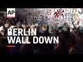 Bulldozer And Demolition Crane Removing Top Sections Of Wall While Crowds Cheer And Shout