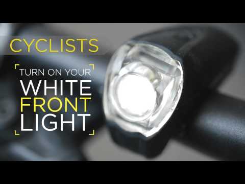 Image of a bike light with the caption: Cyclist: turn on your white front light