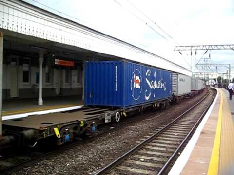 Freightliner class 90 electric locomotive pulls container train through Camden Road station.