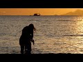 Silhouettes Of Mother And Daughter Walk On Sea Water Surface On Dramatic Sun Set