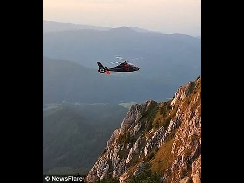 Moment heroic helicaftor pilot performs saves person standed on cliff