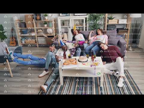 Tired men and women sleeping on couch and floor after enjoyable party in flat