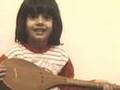 Little girl singing poems while playing Setar 