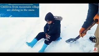 Children from mountain villages are sliding in the snow.
